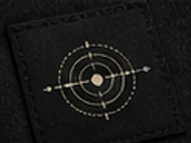 Black woven label with Pressure Signal ring motif
